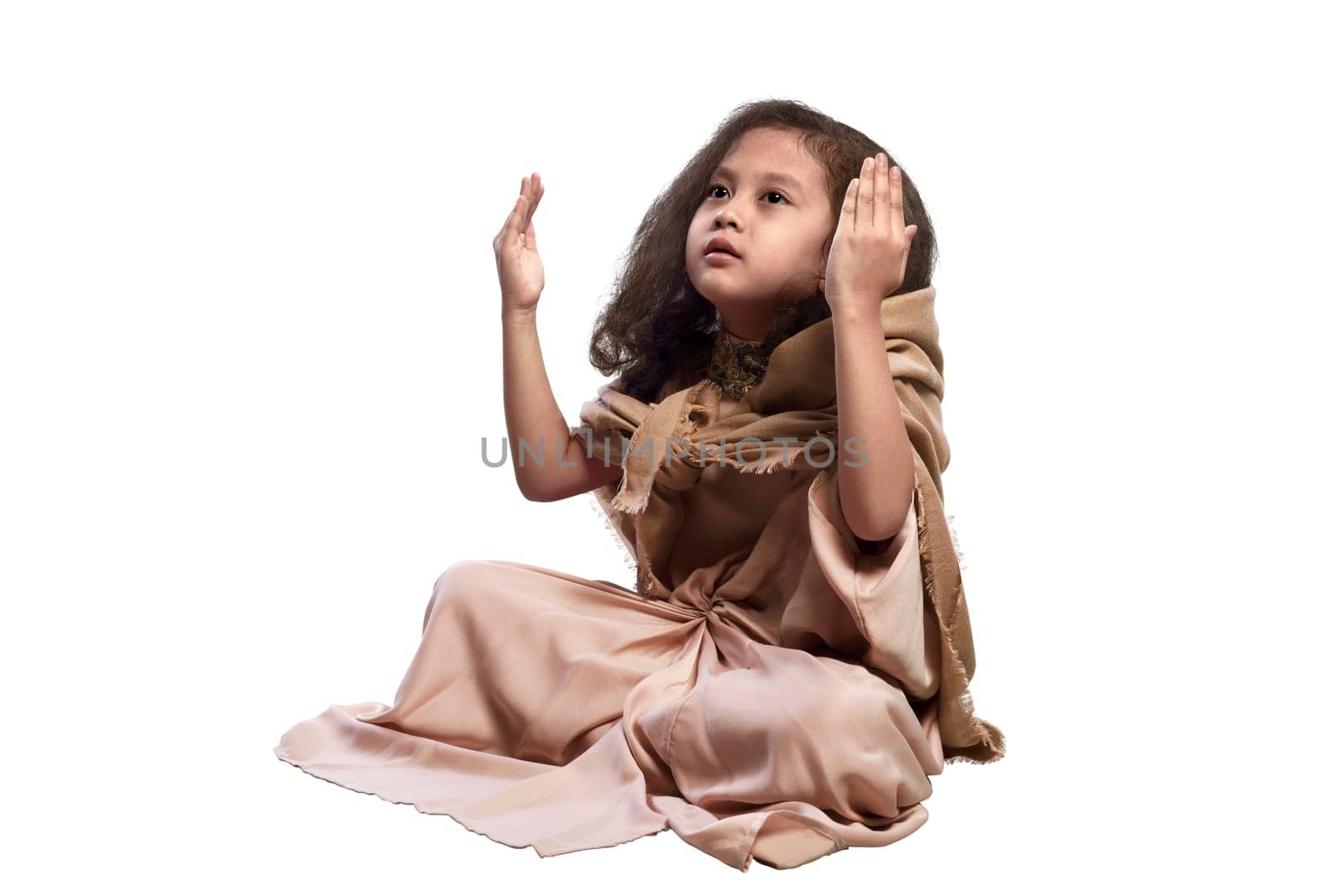 Little asian muslim girl raising hand and praying isolated over white background