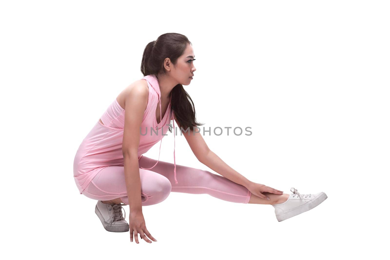 Beautiful asian woman stretching legs before running isolated over white background