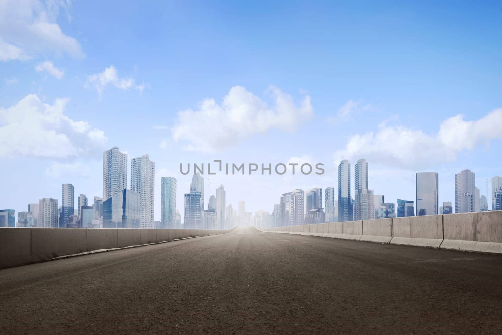 Empty asphalt road and skyscrapers in modern city with blue skyline