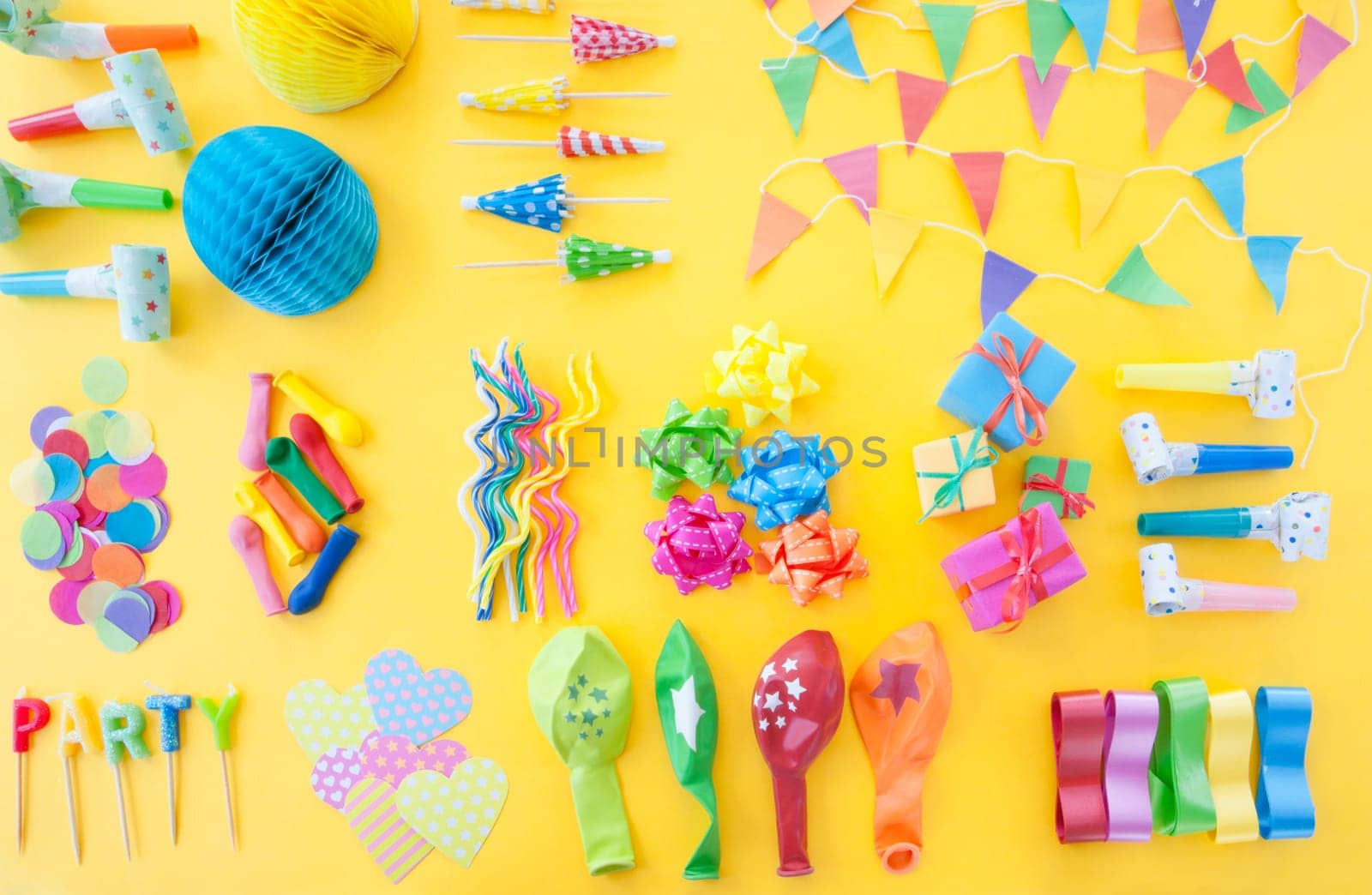 Froehliches buntes Party Zubehoer on yellow background
