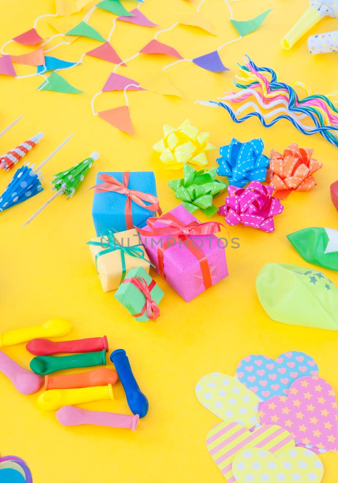 Froehliches buntes Party Zubehoer on yellow background