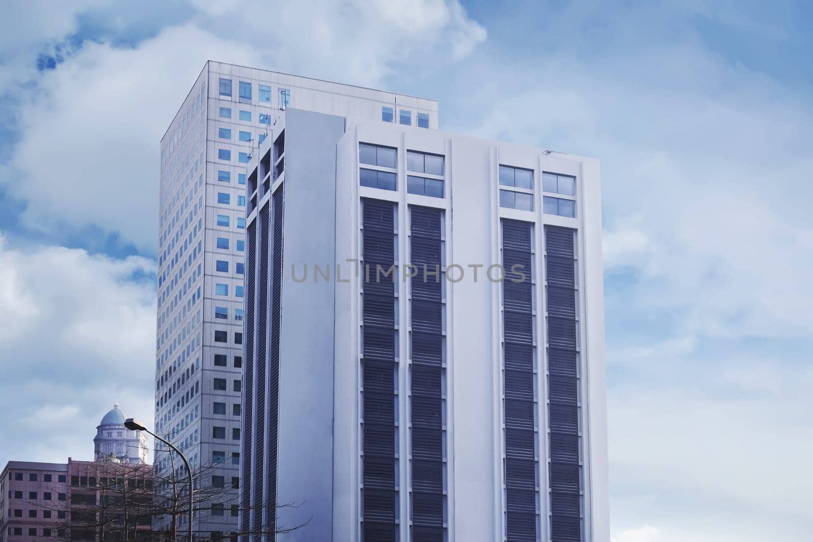 Common modern business office with high rise buildings over blue cloudy sky