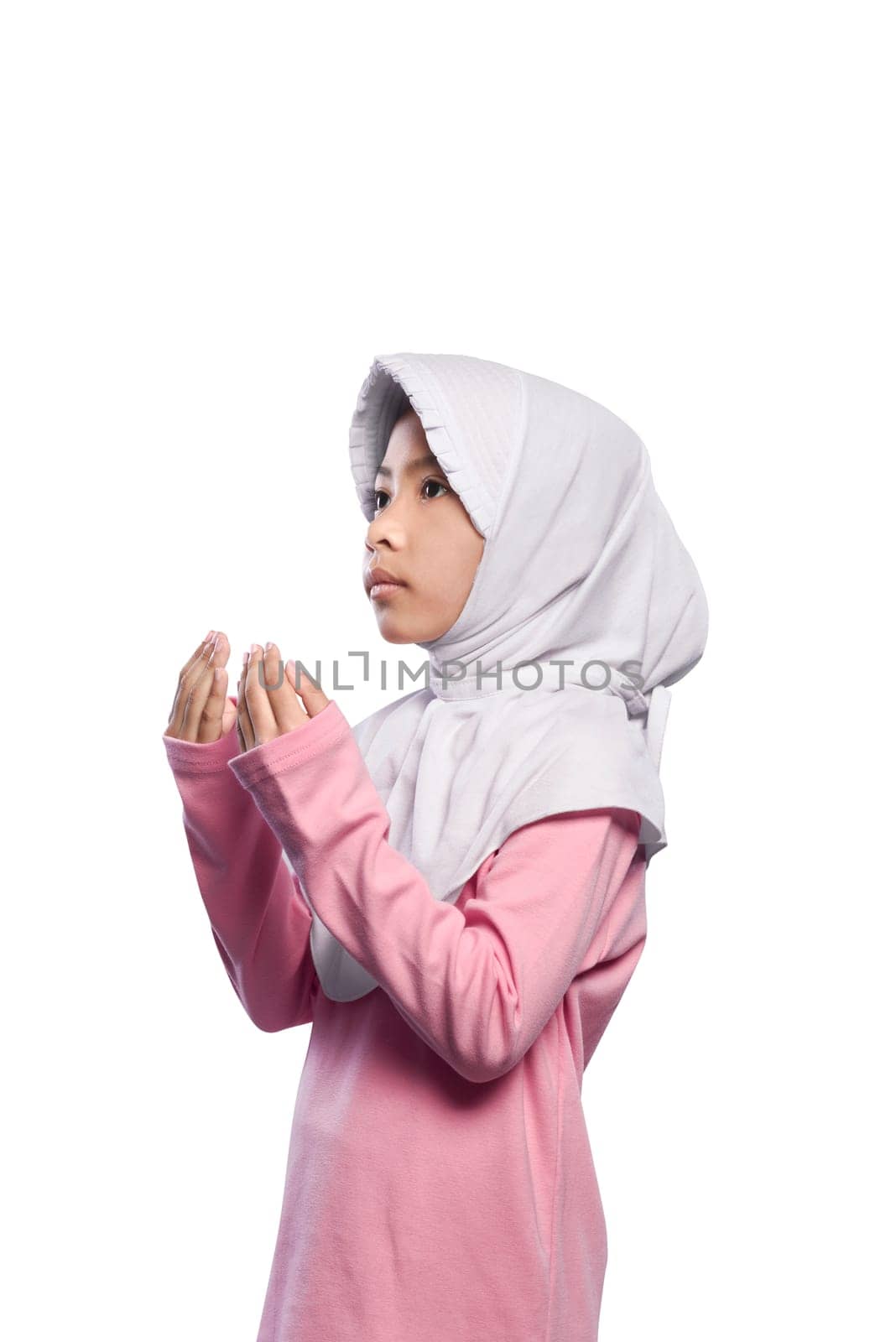Asian muslim girl wearing veil and praying to god isolated over white background