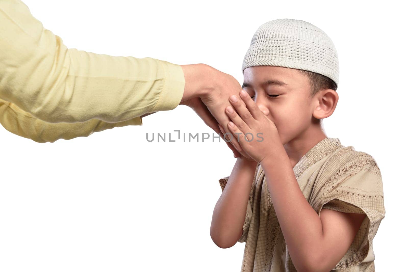 Little asian muslim kid in white cap kissing parents hand isolated over white background