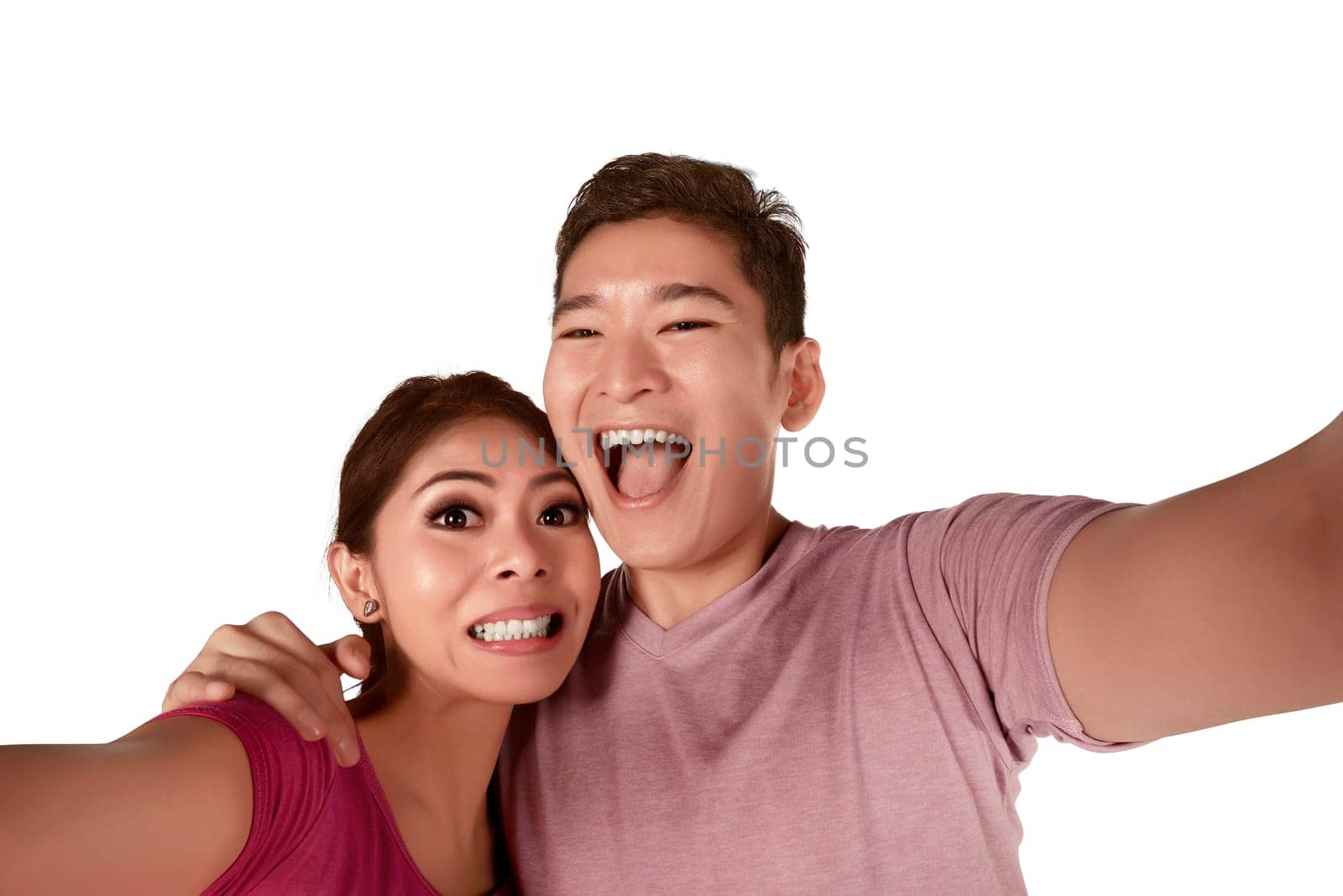 Funny asian couple taking selfie isolated over white background
