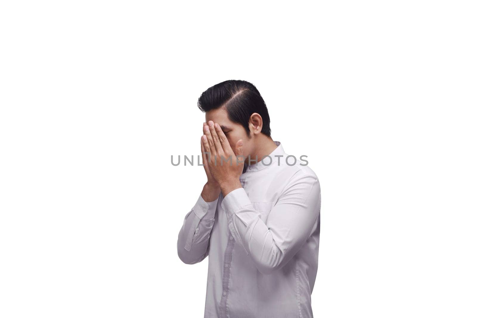 Young asian muslim in traditional dress praying to god isolated over white background