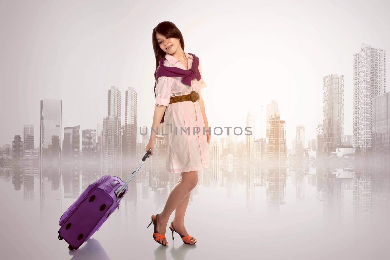 Happy asian woman with scarf holding suitcase against cityscape background