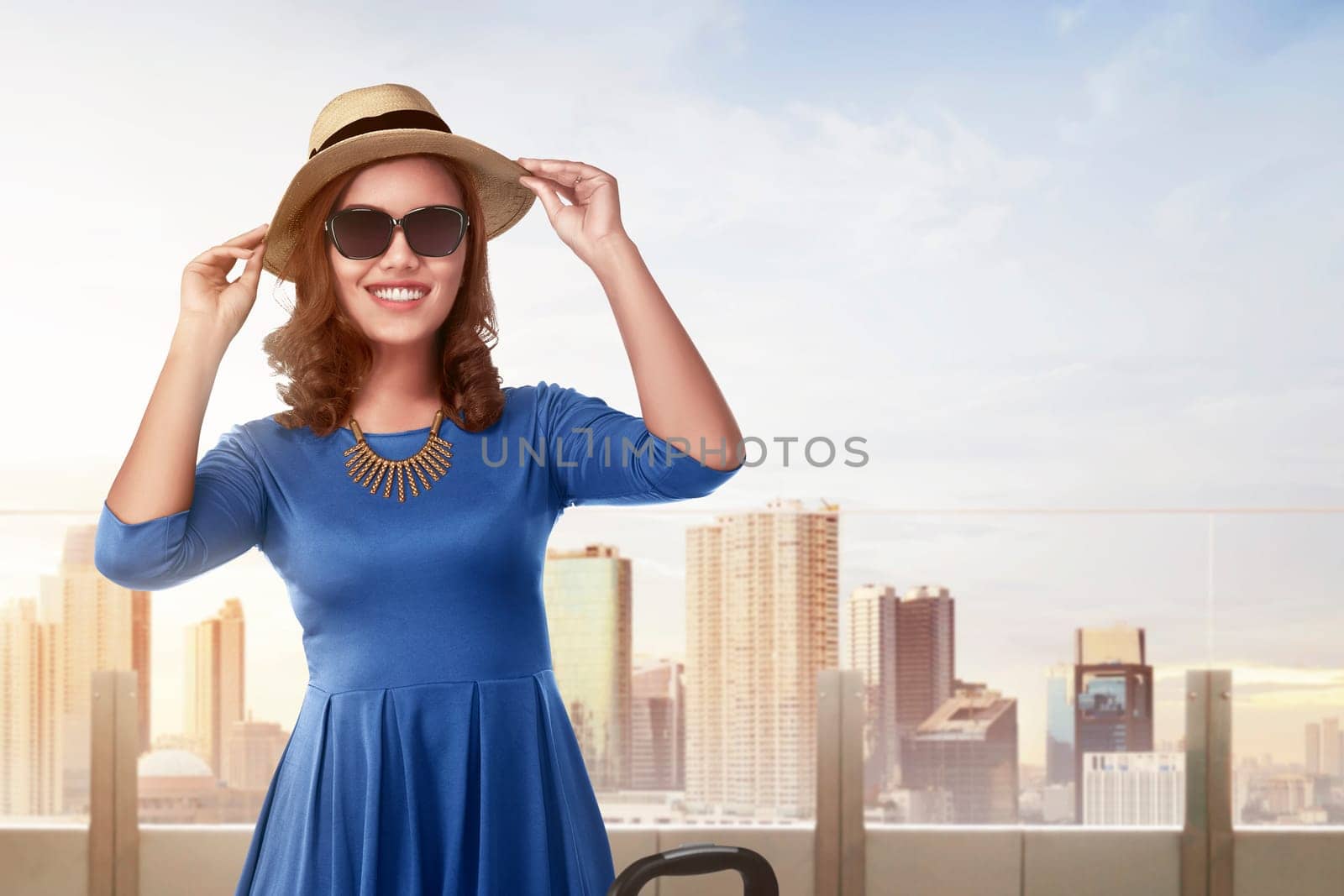 Beautiful asian woman with vintage hat standing in building terrace against skyscraper background