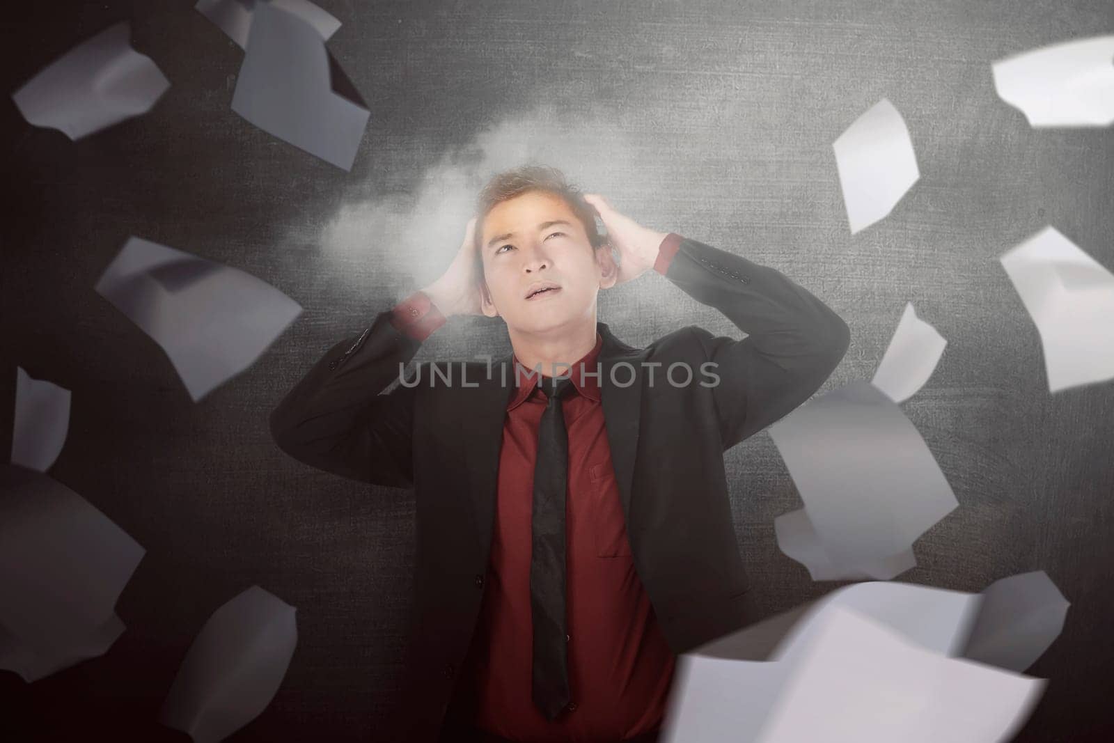 Worried asian businessman full with flying papers being overloaded in the black background