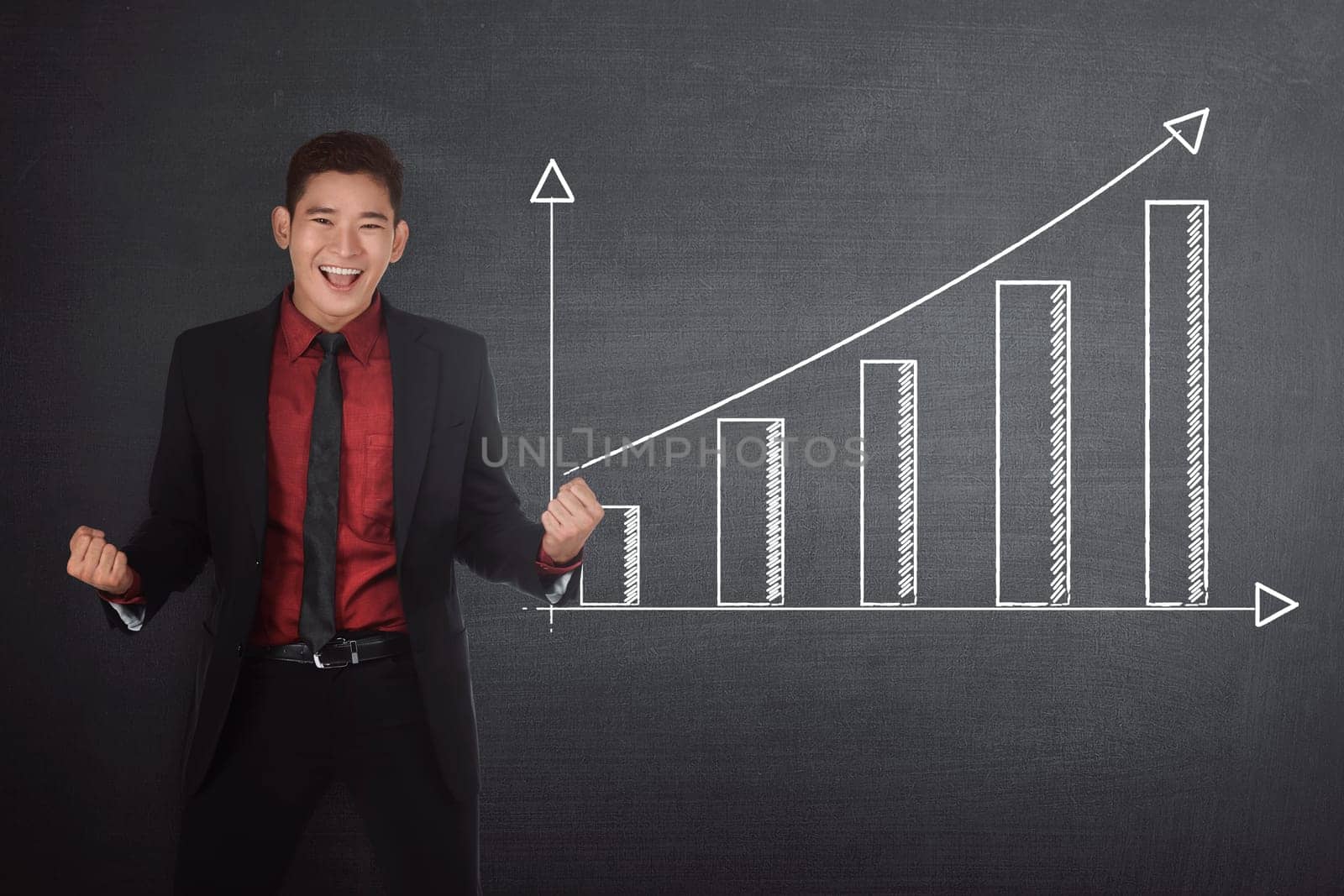 Successful asian businessman standing beside financial graph on the blackboard