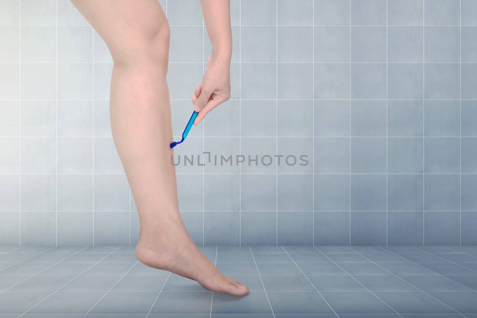 Woman shaving legs with carefully in the bathroom