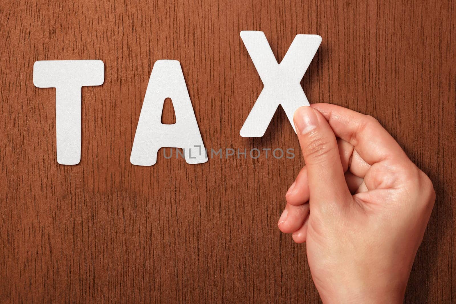 People hand holding Tax alphabet on wooden background
