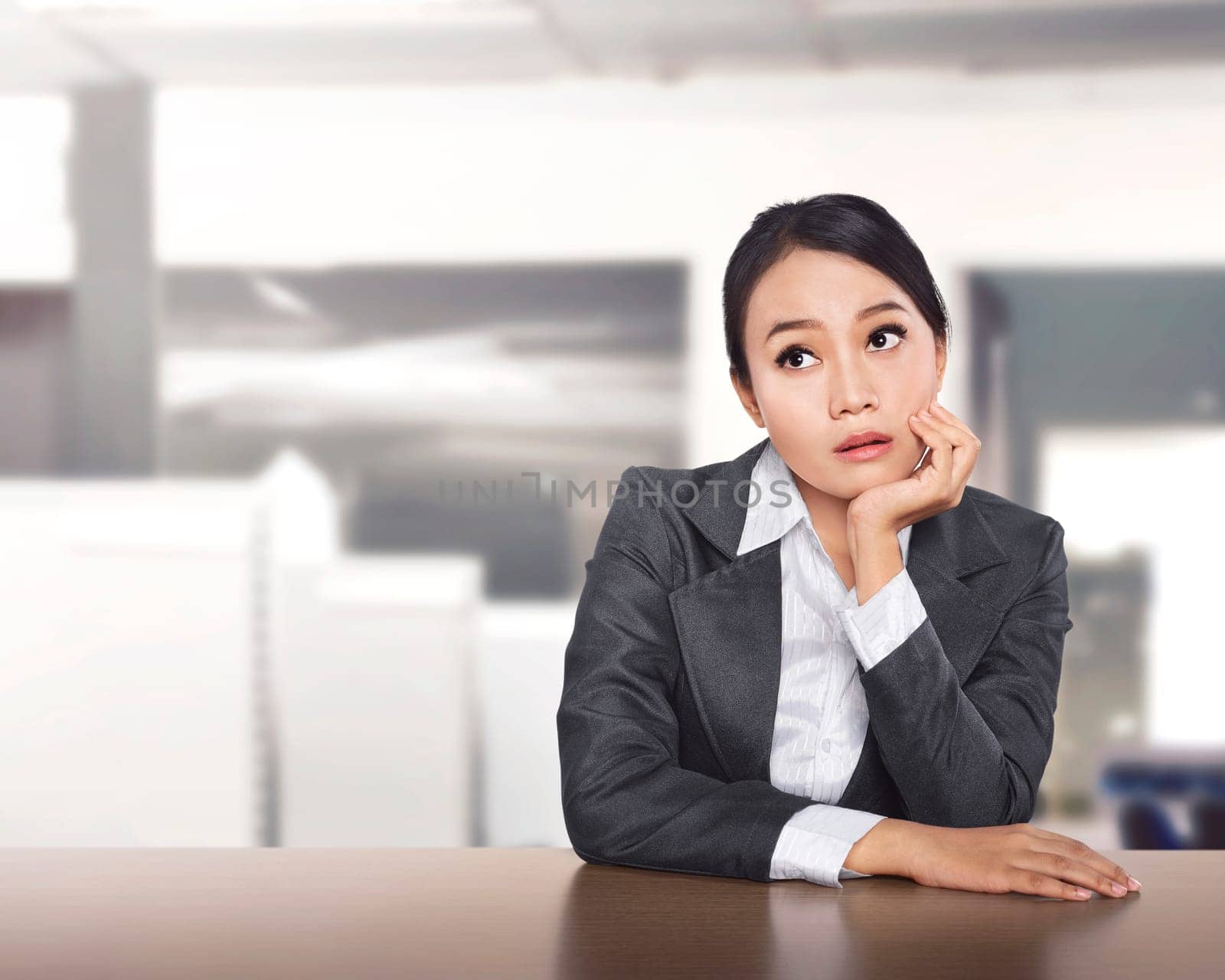 Young asian business woman working at office desk and thinking something on the office
