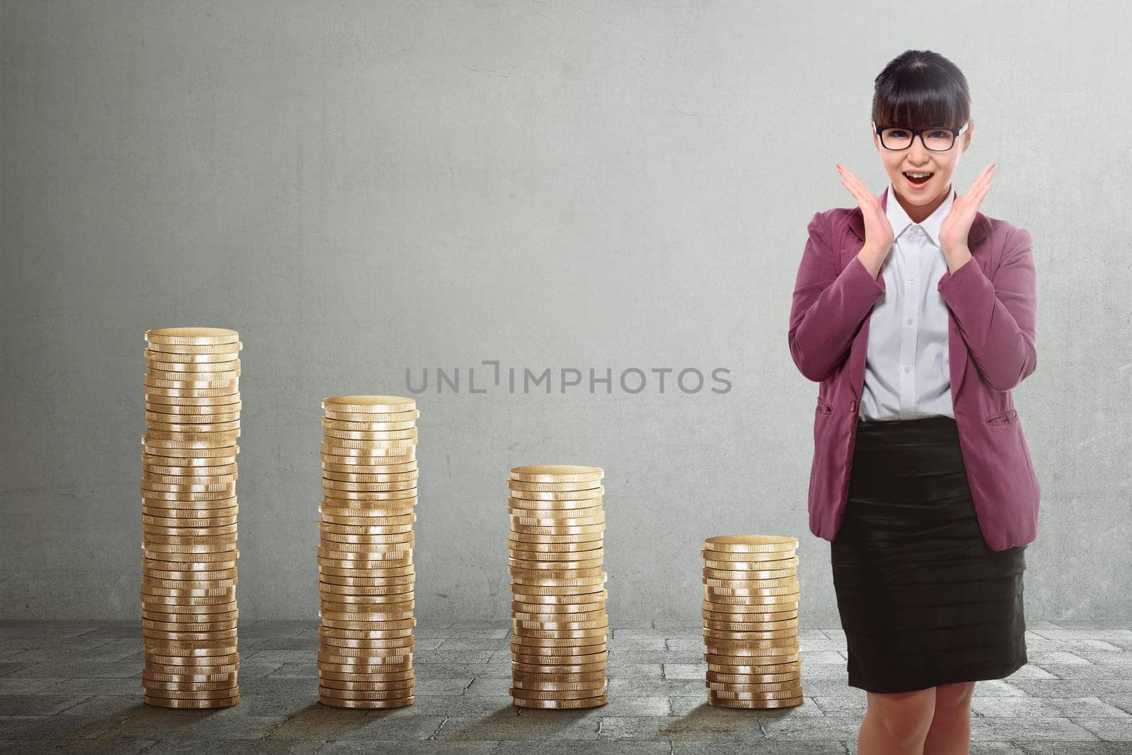 Beautiful asian business woman standing with golden stack coins over grey background