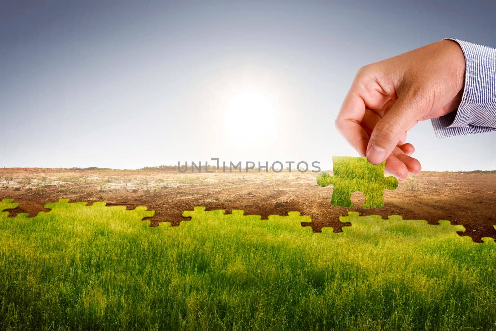 Businessman hand assemble puzzle to build new world with fresh environment. Climate change concept.