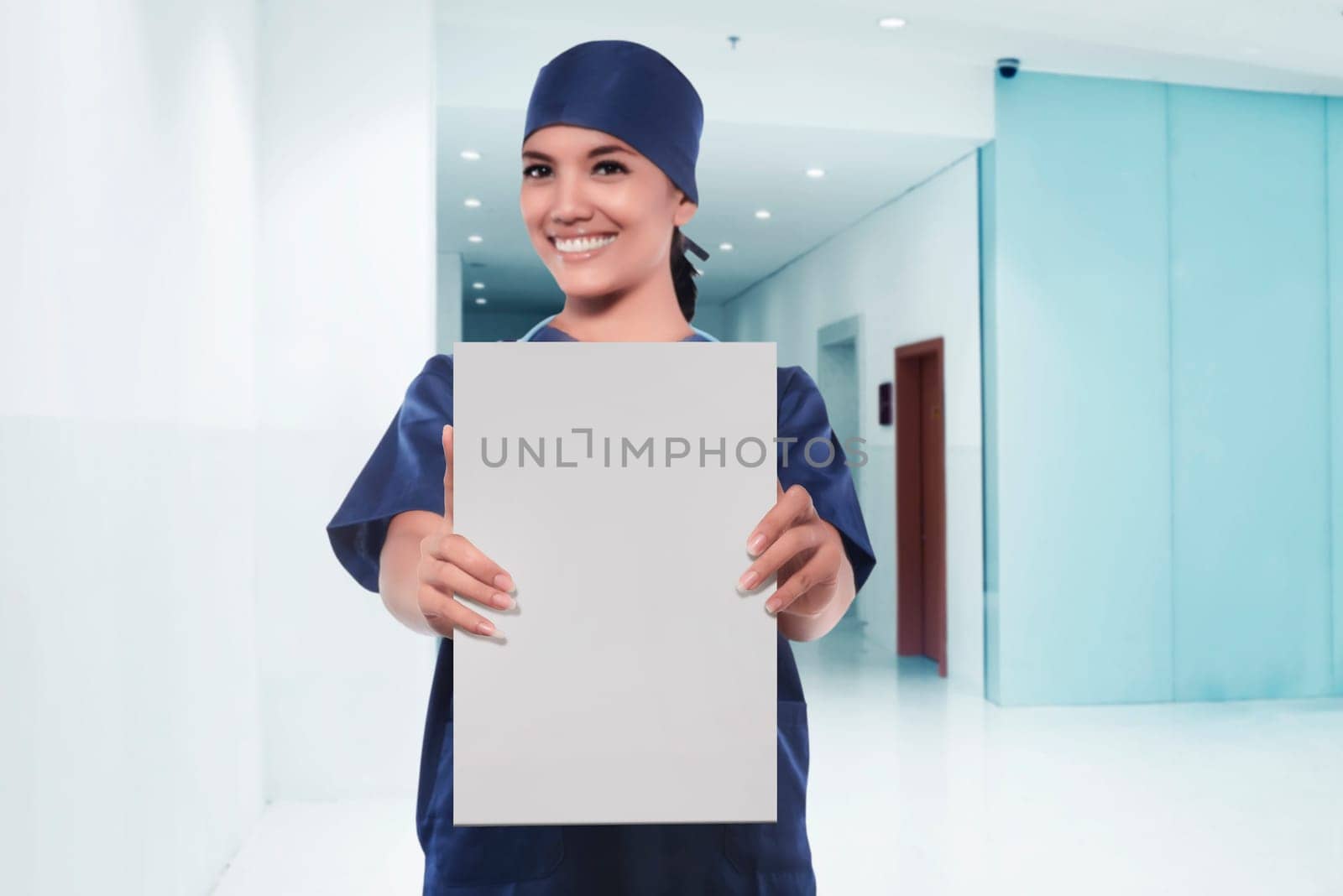 Happy asian woman nurse showing empty white board in a hospital