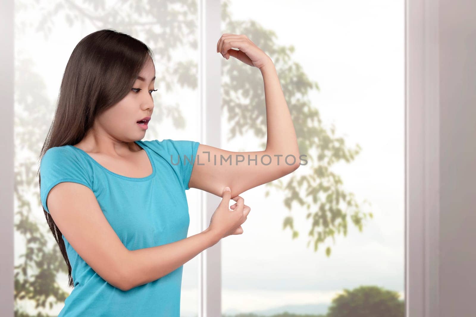 Young asian women weight loss on her arm with window glass background