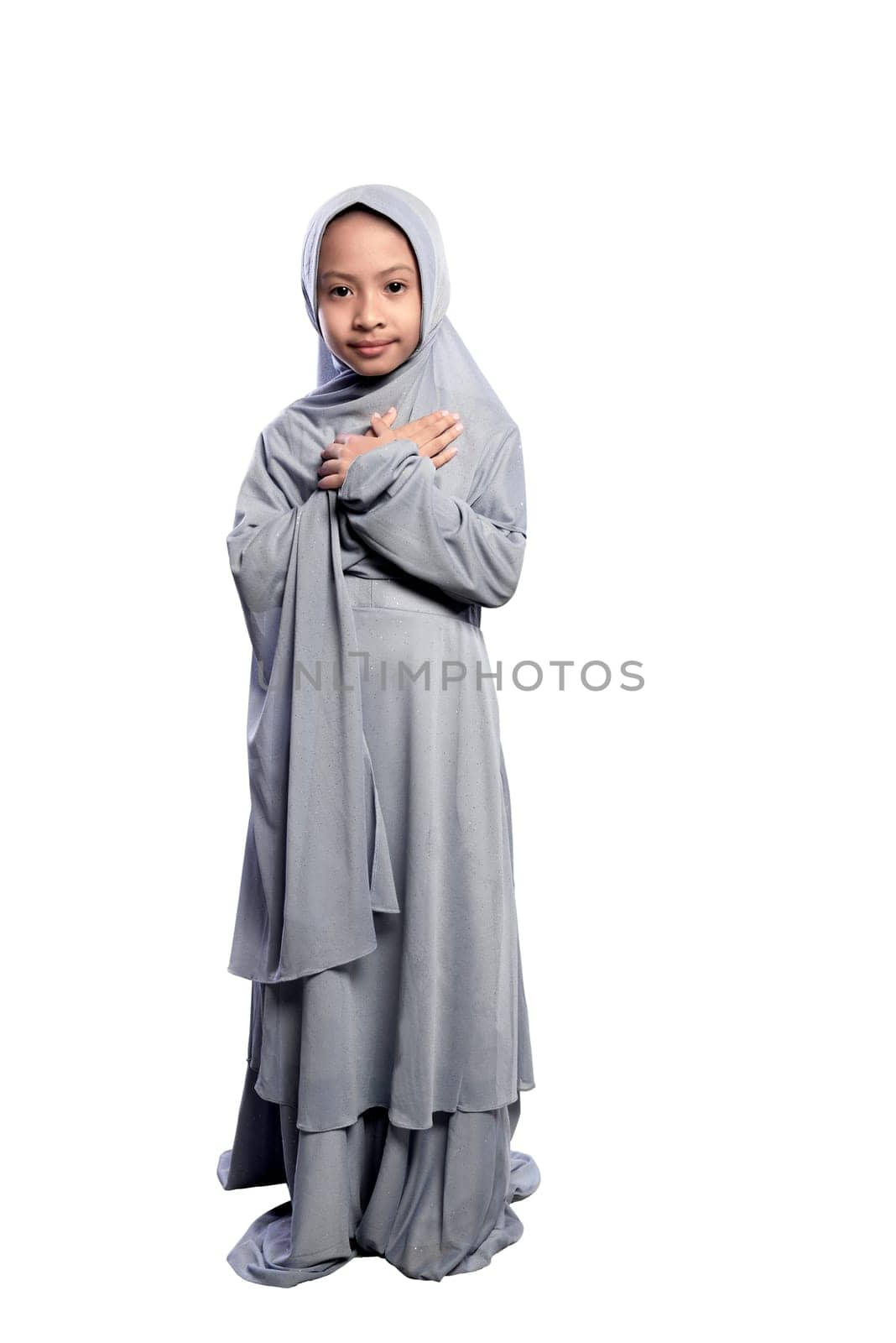 Portrait of asian muslim child wearing hijab standing isolated over white background