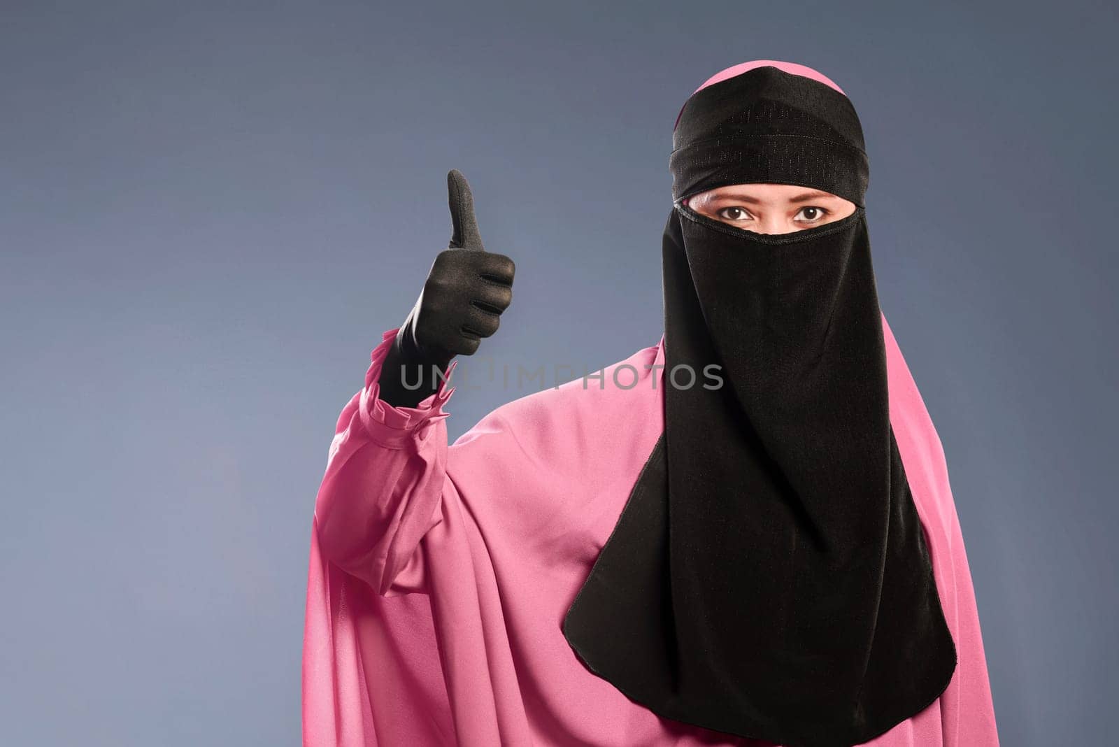 Portrait of asian muslim woman in hijab showing fine sign over dark background