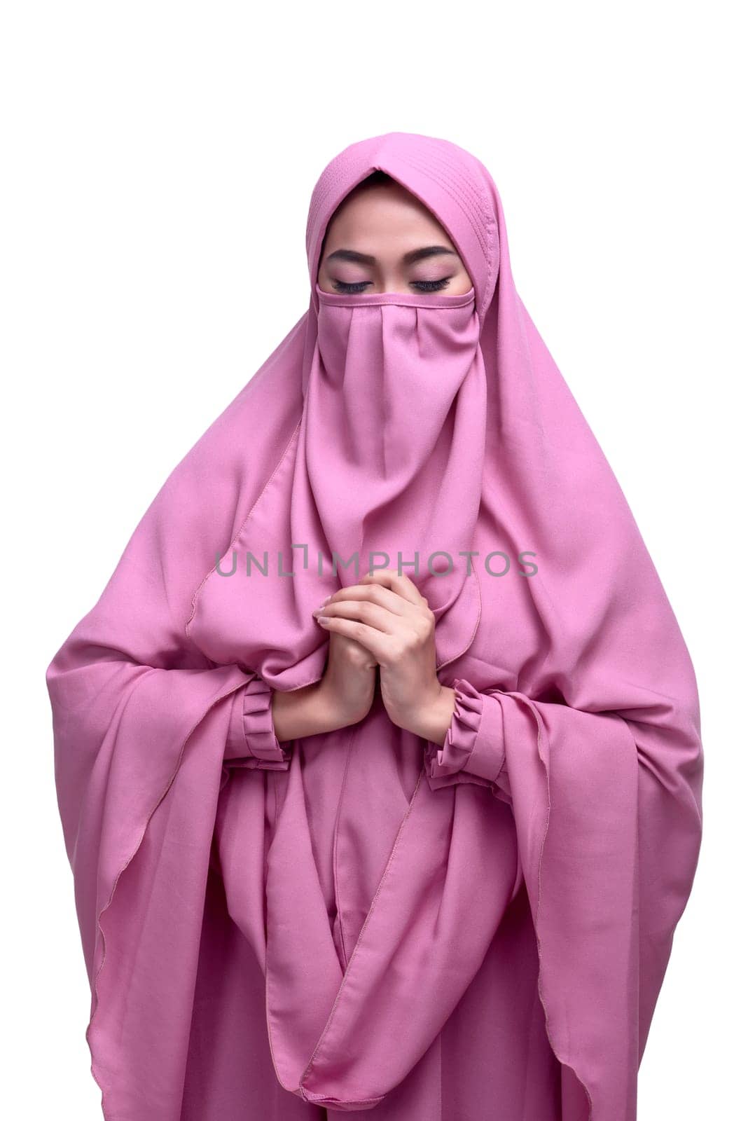 Religious asian muslim woman with niqab dress praying isolated over white background