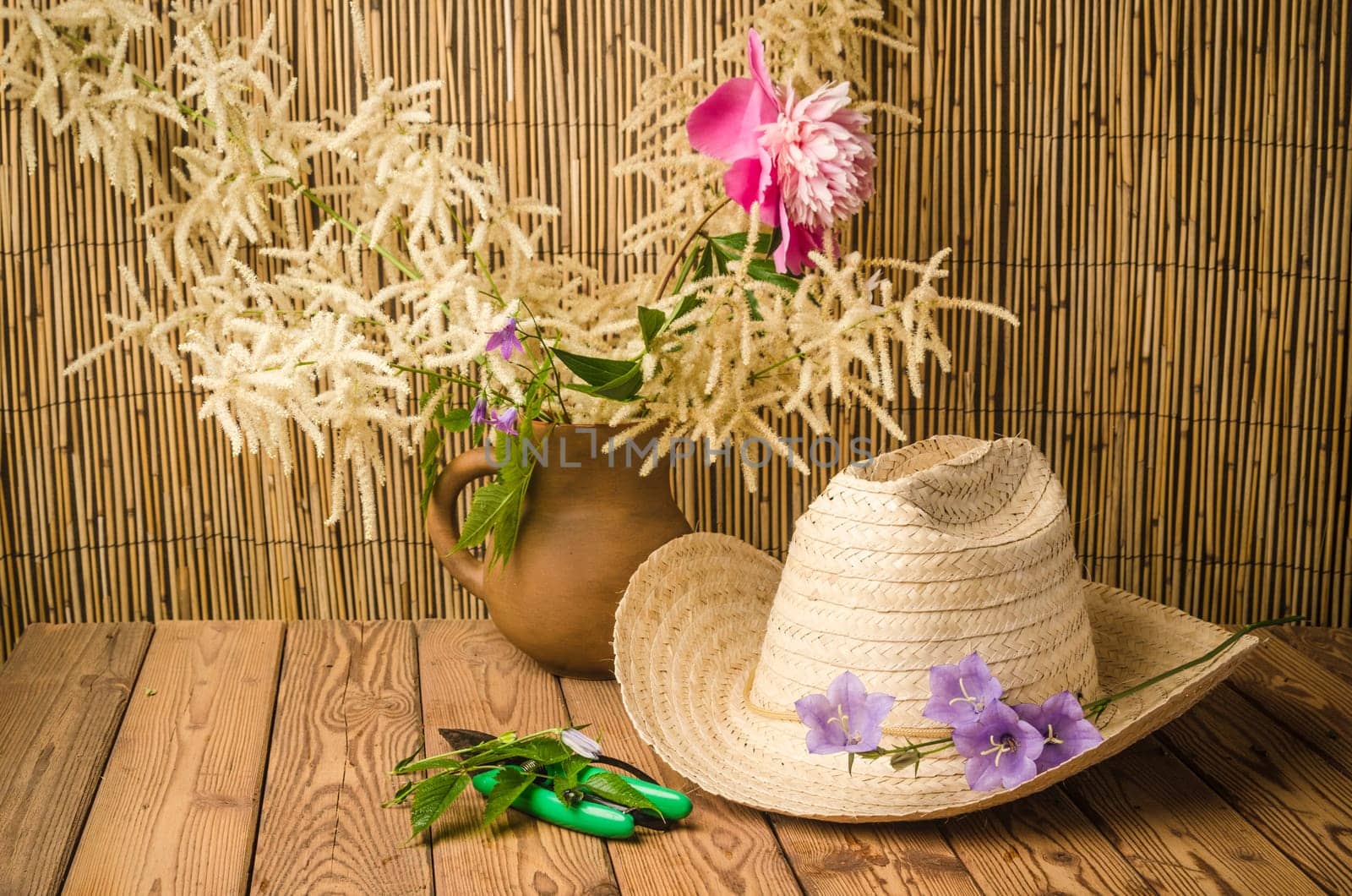 Straw hat and flowering campanula, close-up