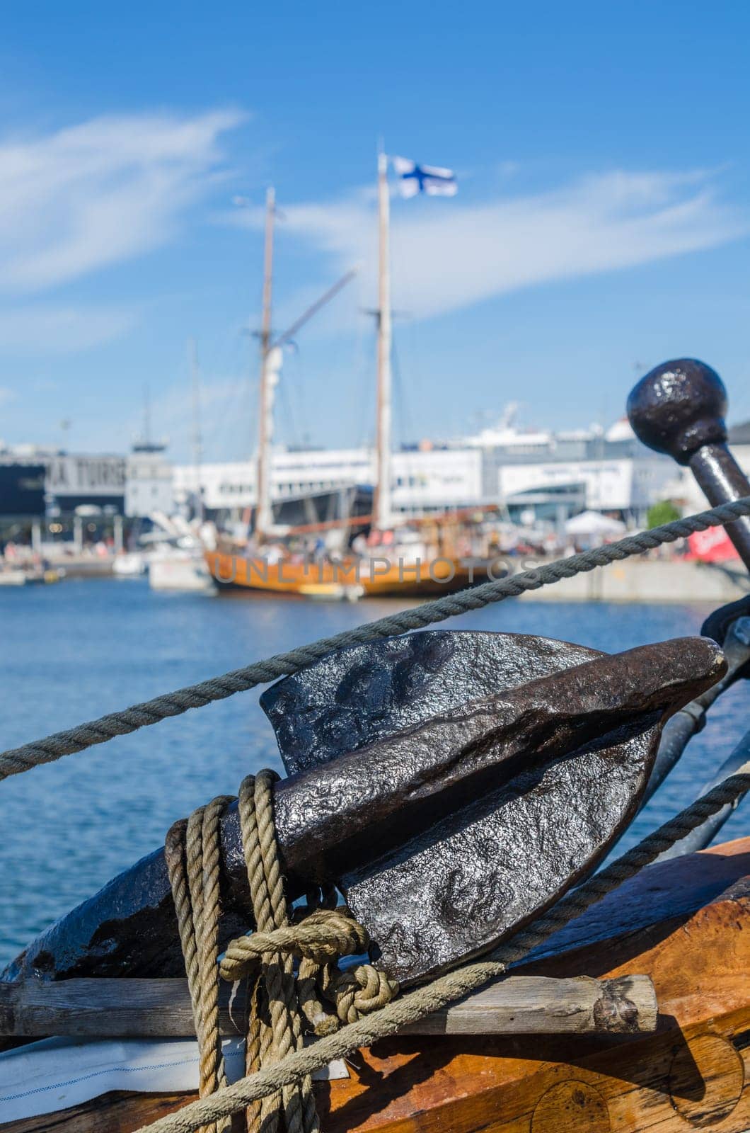 Old rusty anchor at a board of the old sailboat