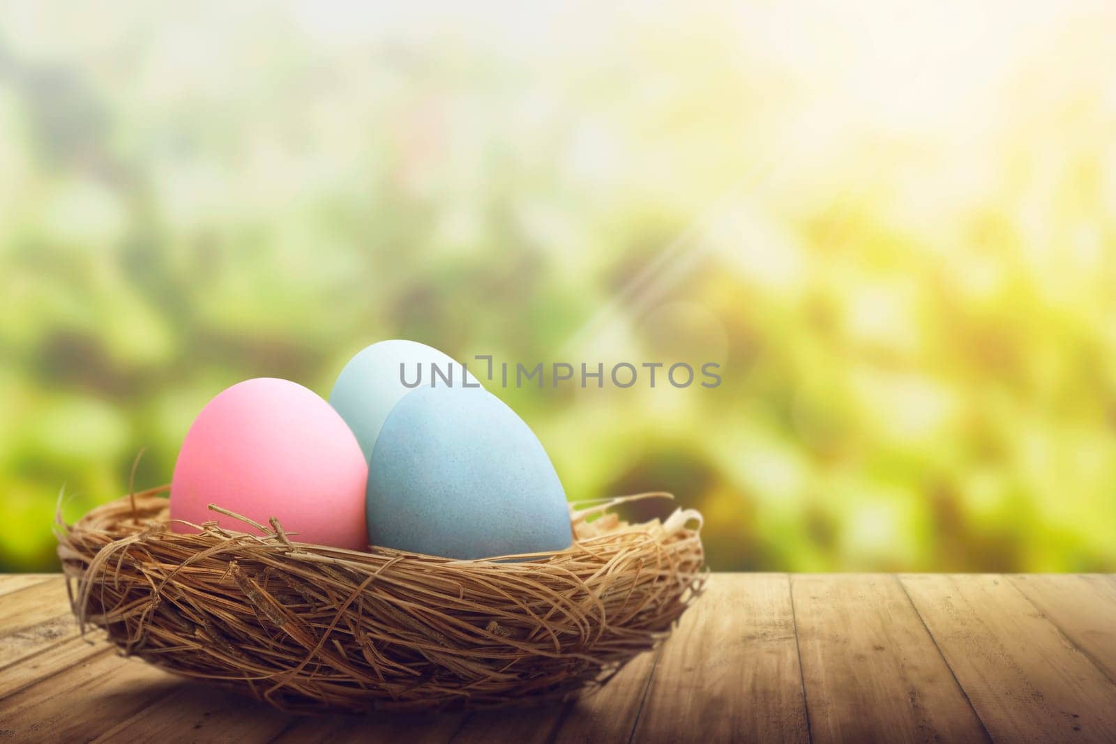 Colorful easter eggs in the nest on wooden floor over blurred background