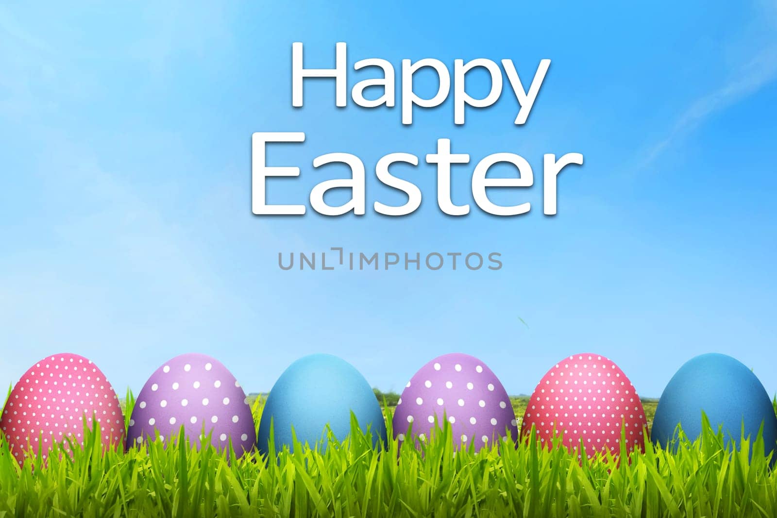 Easter eggs with happy easter greeting in the green field meadow
