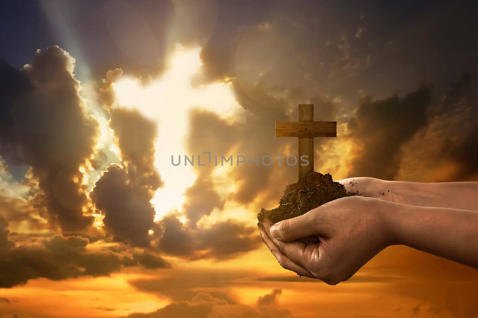 Human hand holding christian cross with soil on the hand under sunset background