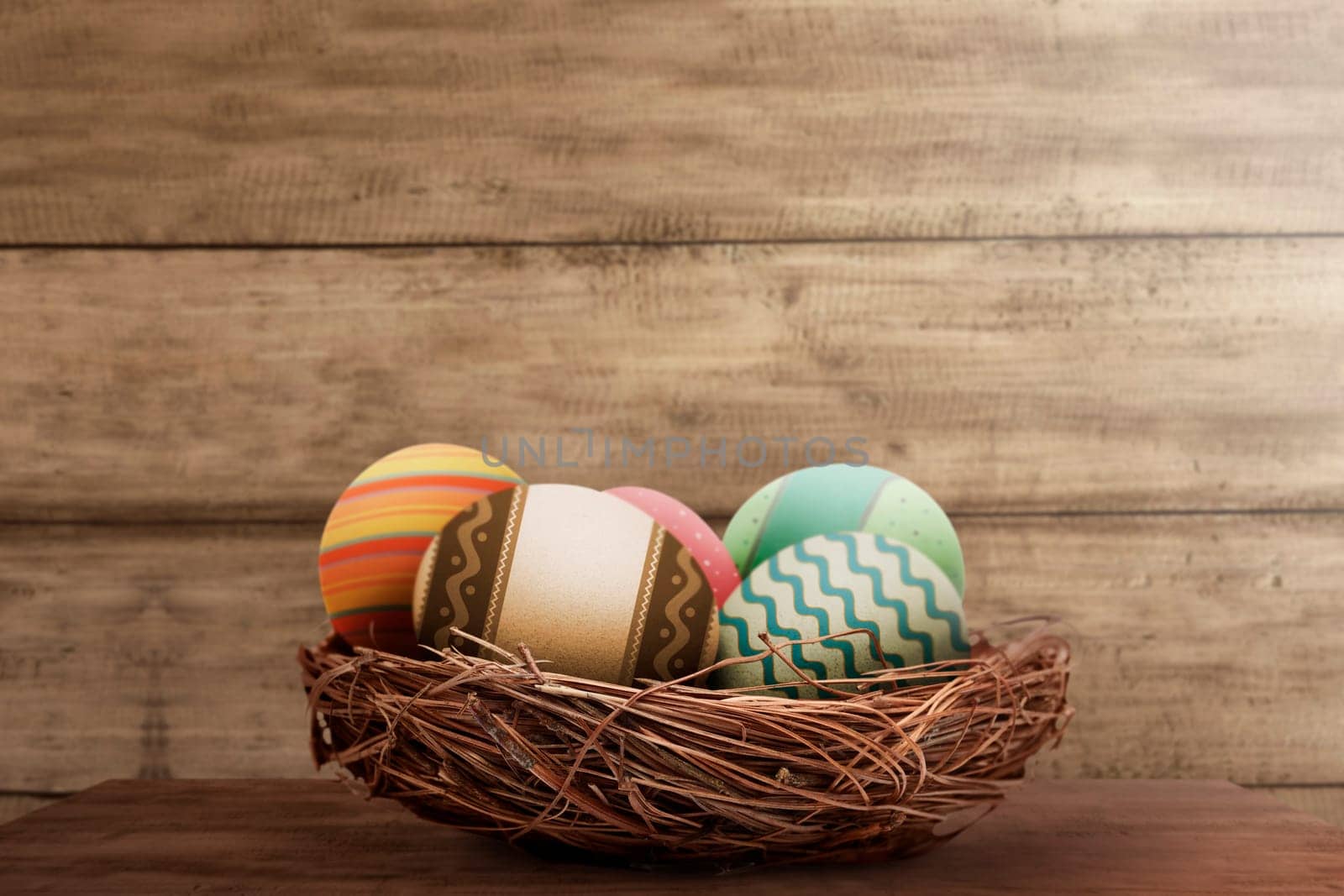 Colorful easter eggs in basket on wooden background