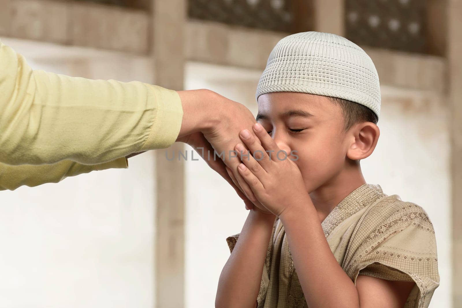 Asian muslim child kissing a hand from an old people in the mosque