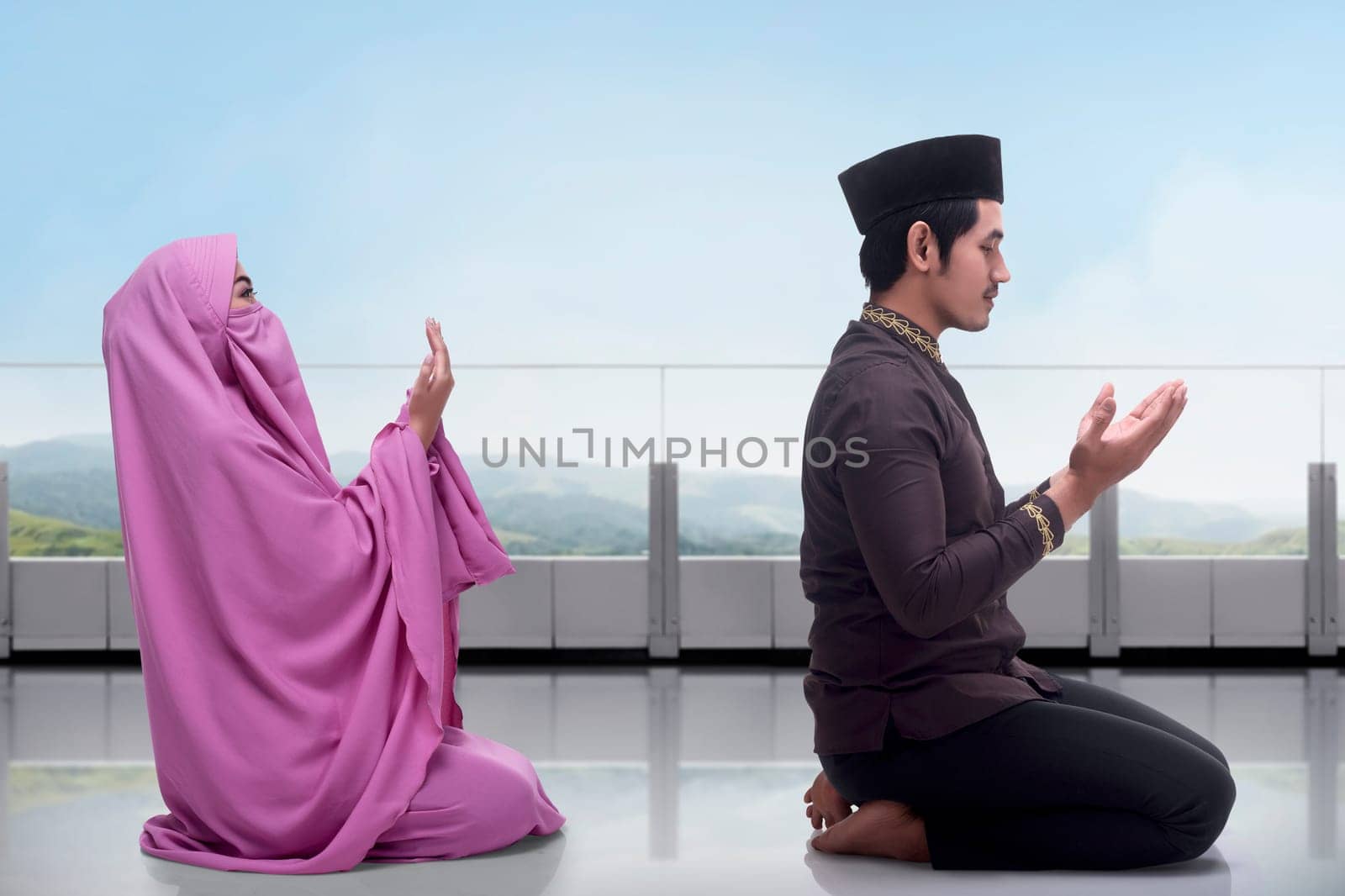 Asian muslim man and woman praying together with view landscape background