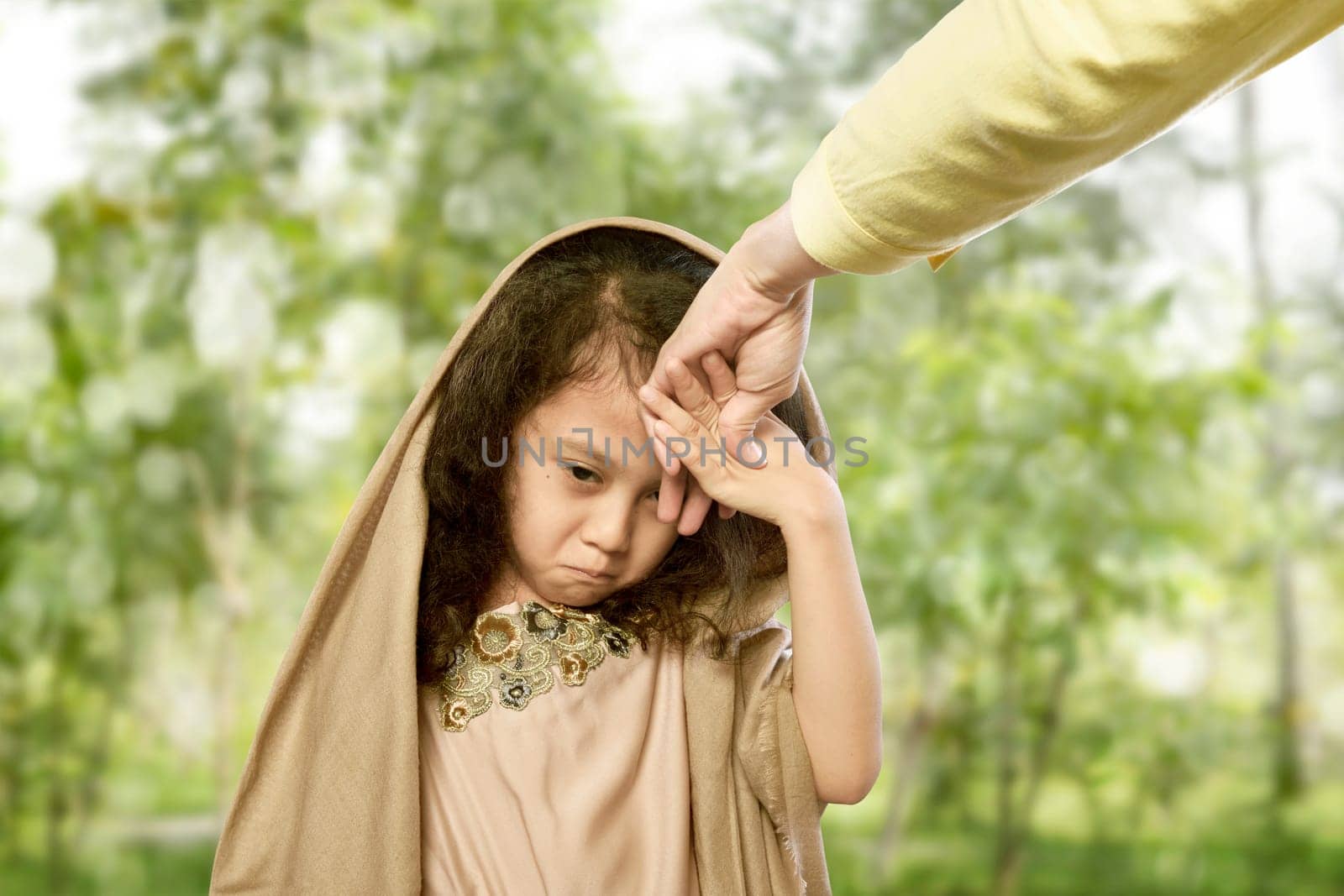 Asian muslim child kissing hand parents for traditional act of respect at outdoor