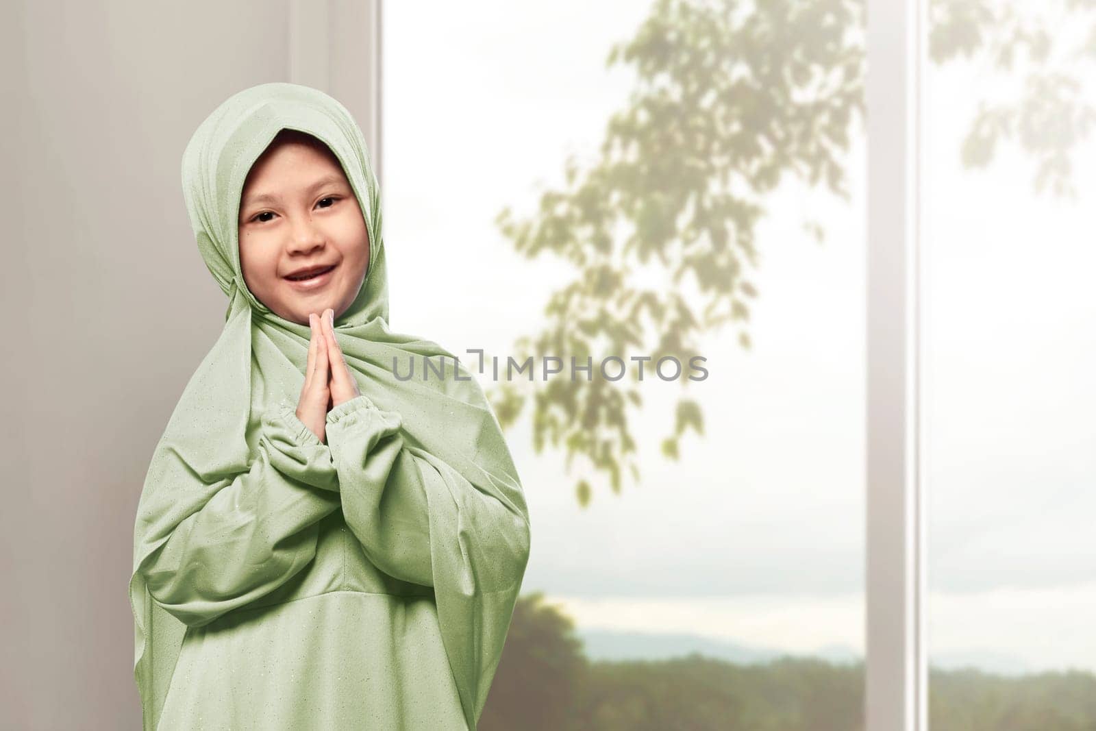 Asian muslim girl wearing hijab praying in the home