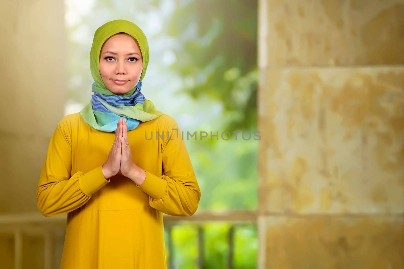 Smiling asian muslim woman on praying in the mosque