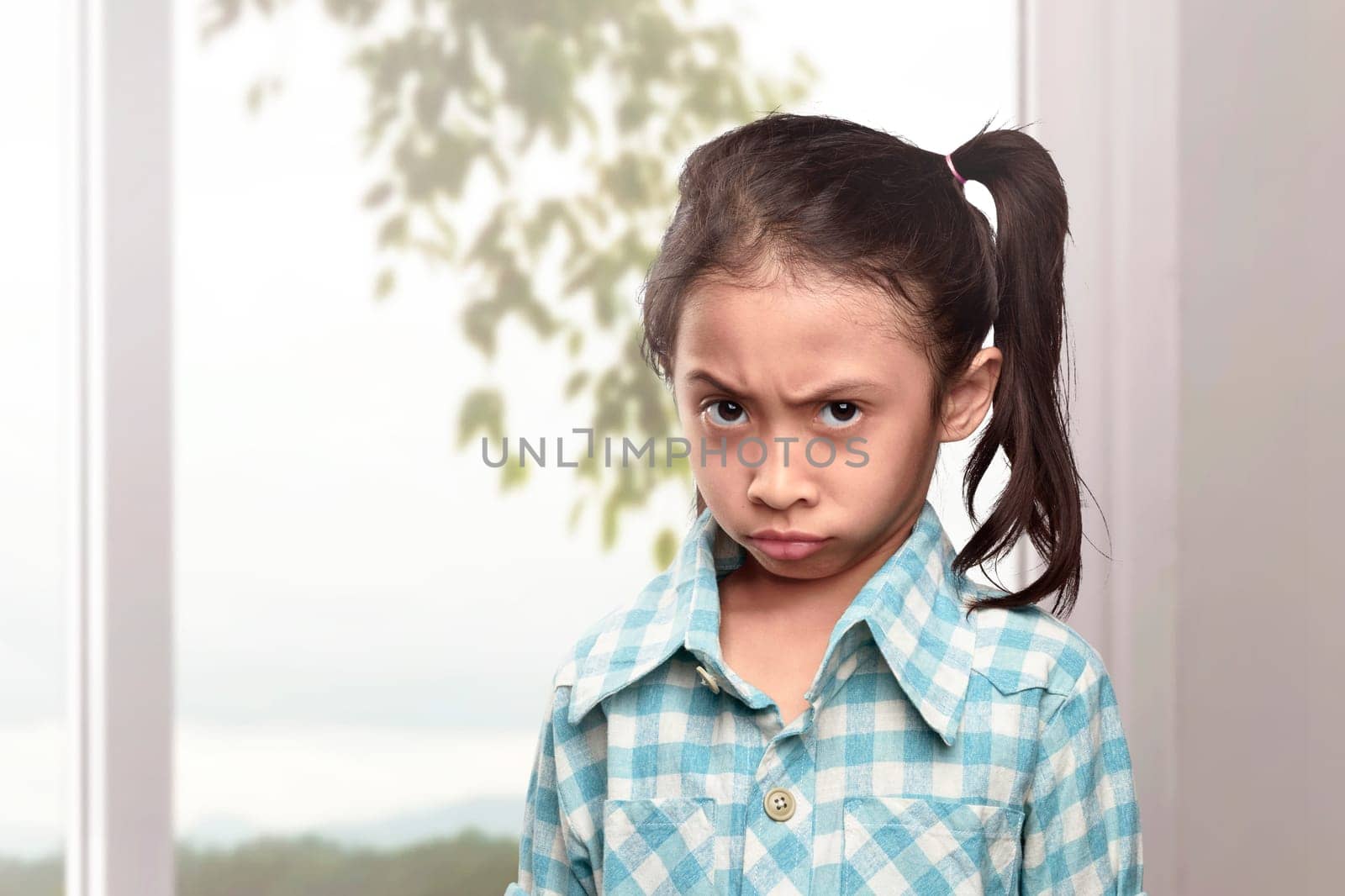 Portrait of asian little girl with unhappy face in the home