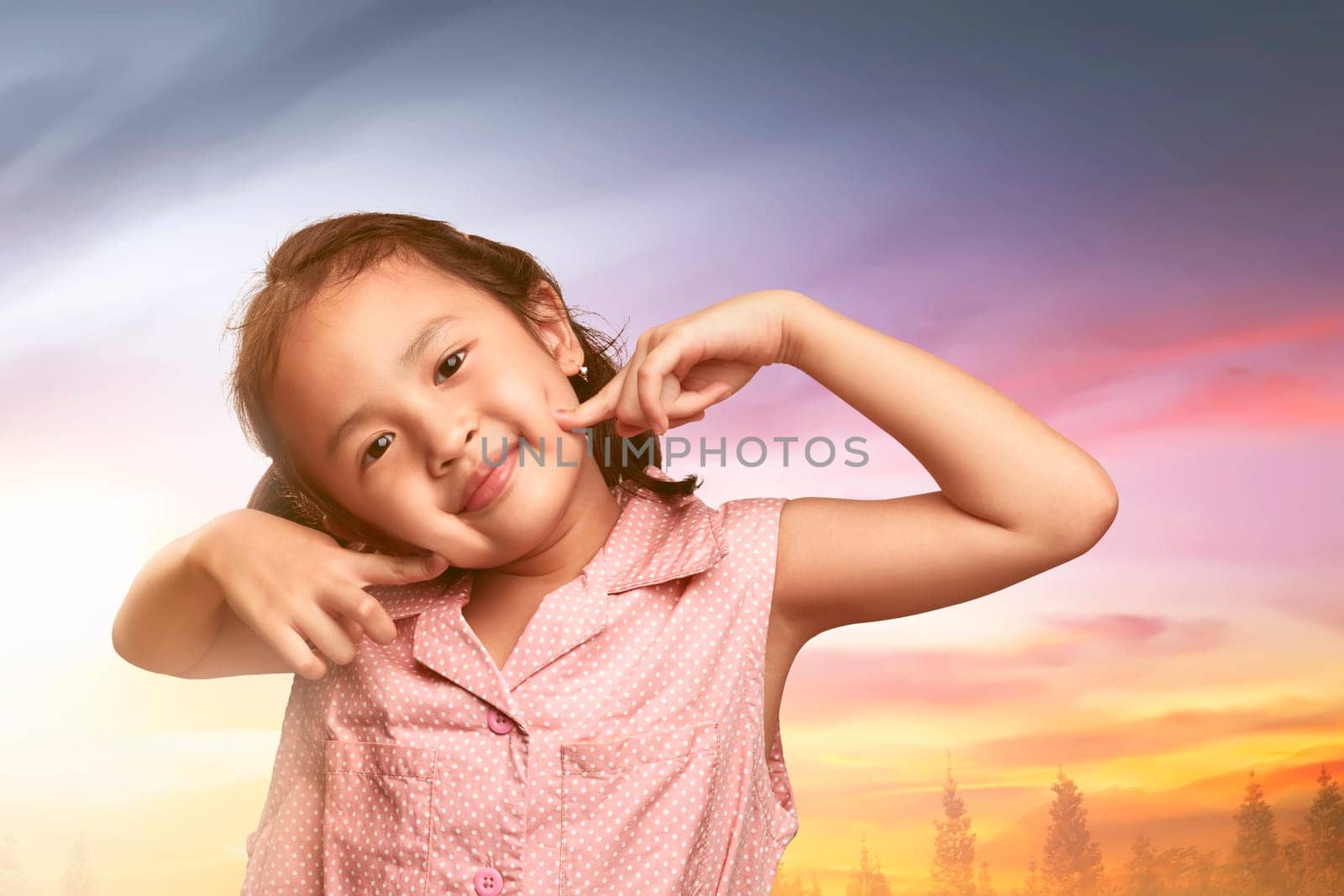 Smiling asian little girl with fun happiness expression in the park at sunset