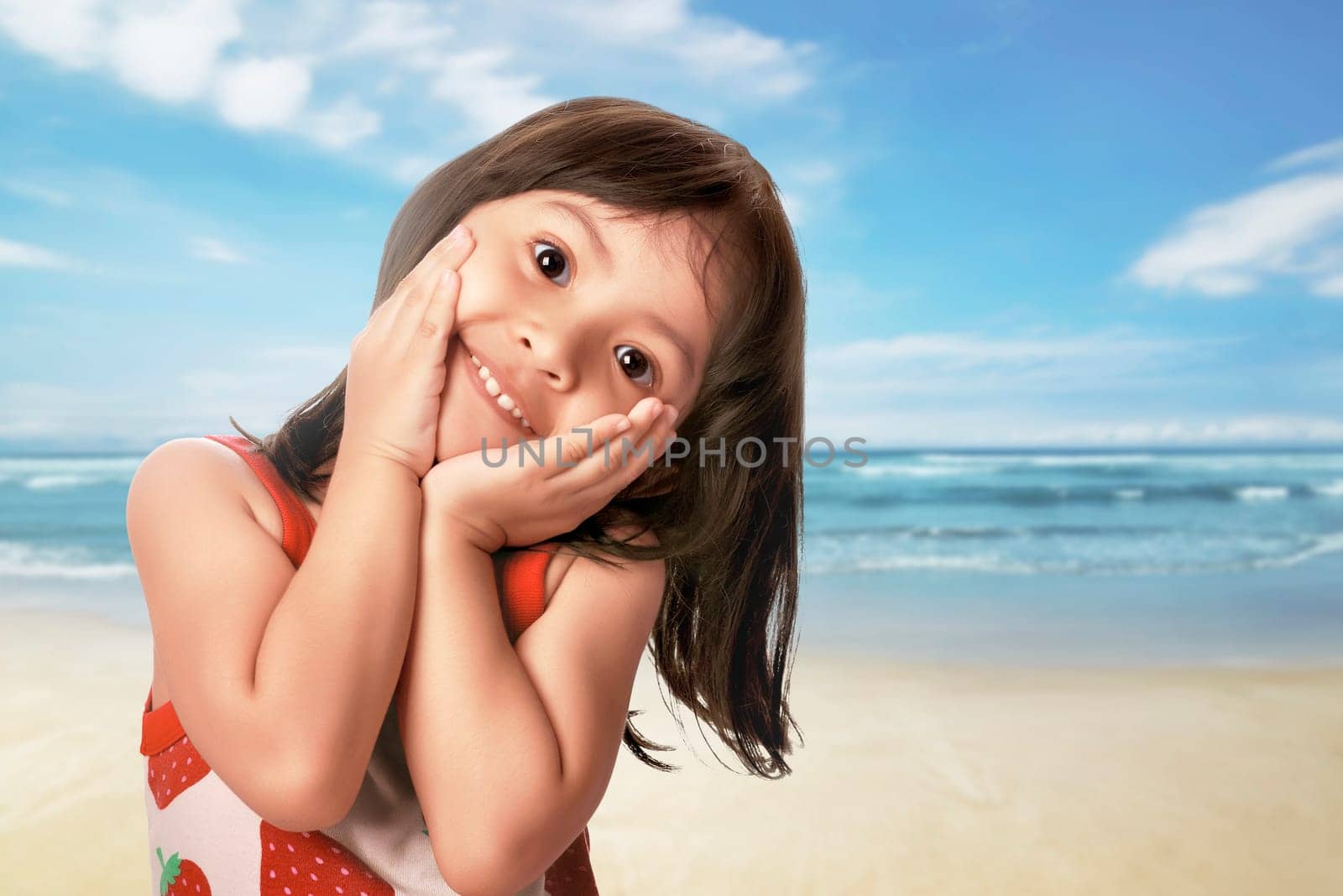 Beautiful asian child with funny expression in the beach