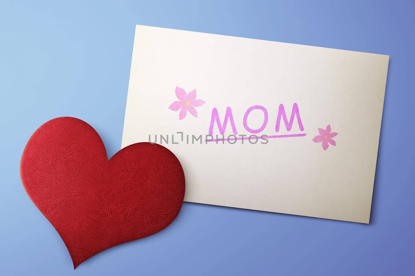 Mothers Day message on paper with red hearts against blue background