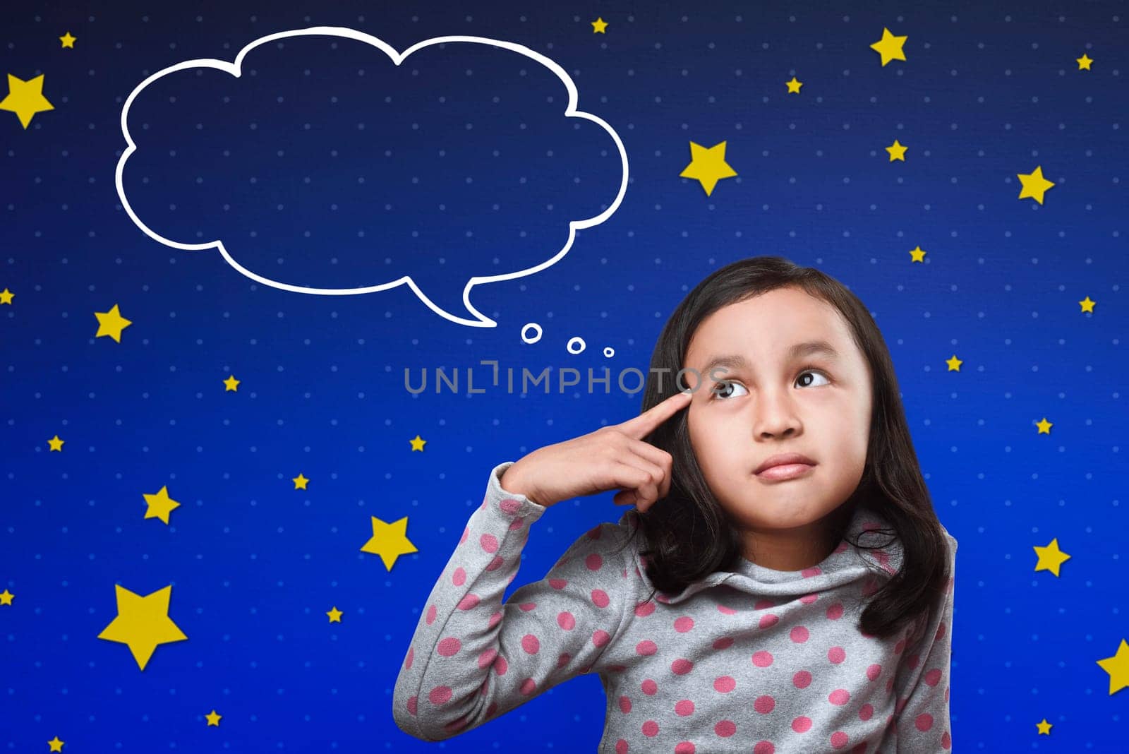 Cheerful asian child thinking with cloud space for text on the bright blue sky background