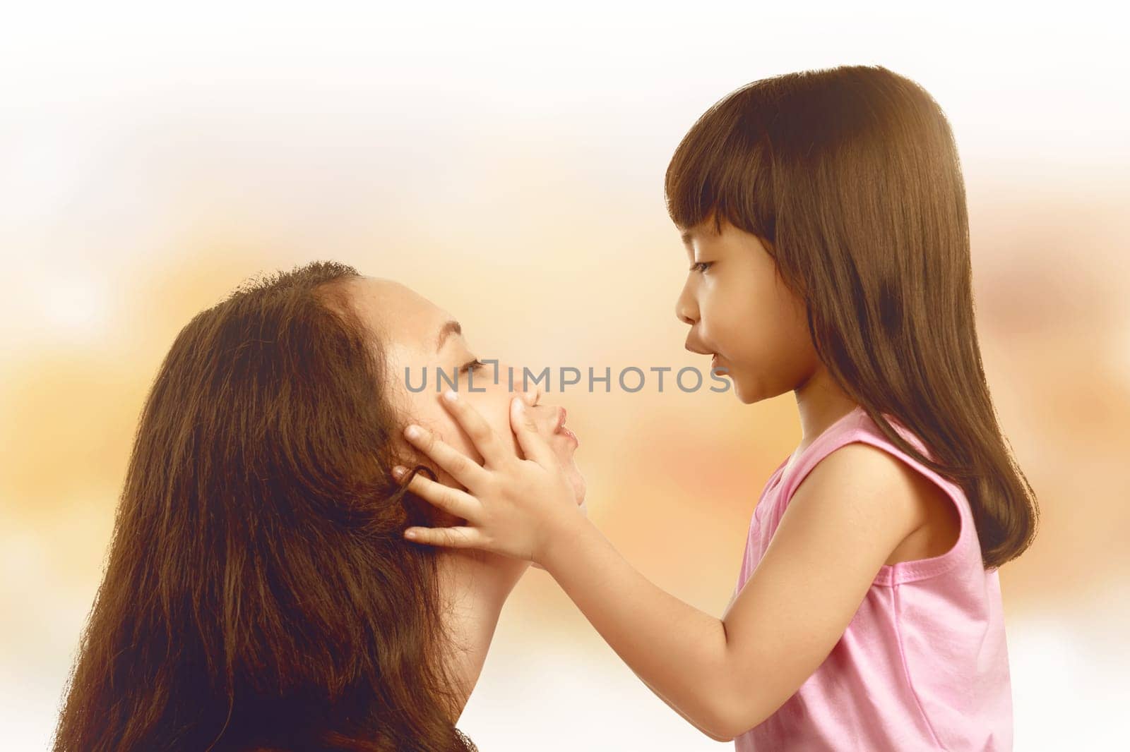 Young mother and her little daughter against light background. Mothers day Concept.
