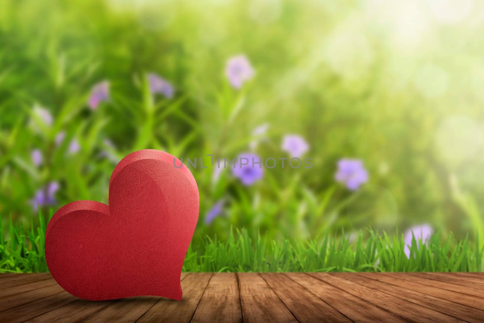 Red heart lying on wooden floor with garden background