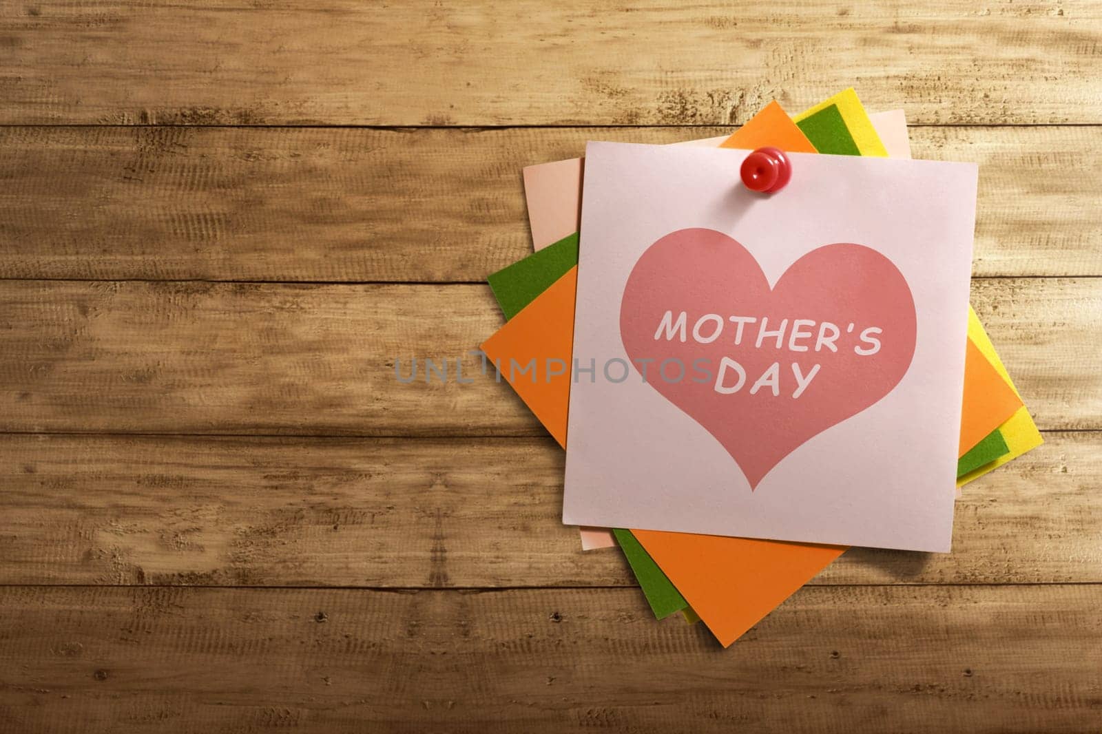 Mothers Day message written on stack of colorful paper note on wooden wall