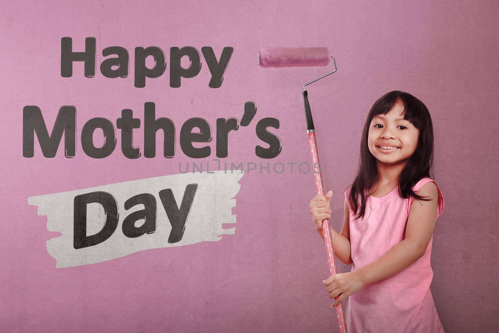 Happy asian little girl holding roller brush paint Happy Mothers day message over pink wall background
