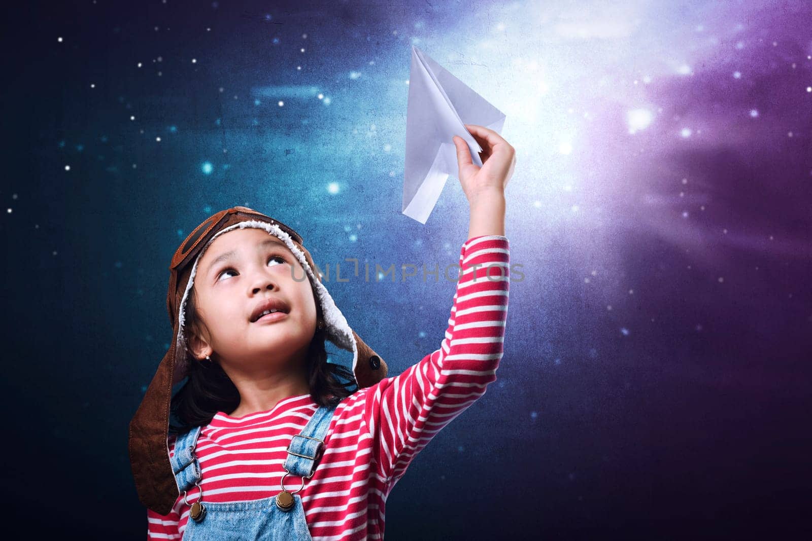 Beautiful asian little girl having fun with paper airplane toy over futuristic background