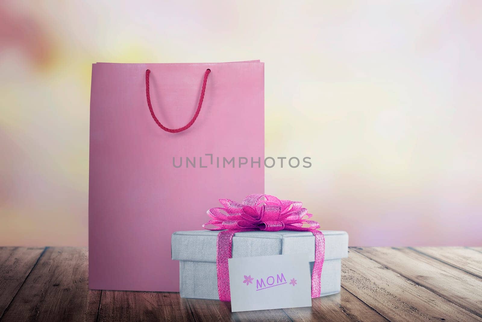 Shopping bag with gift box with pink ribbon for mom. Mother's Day Concept.