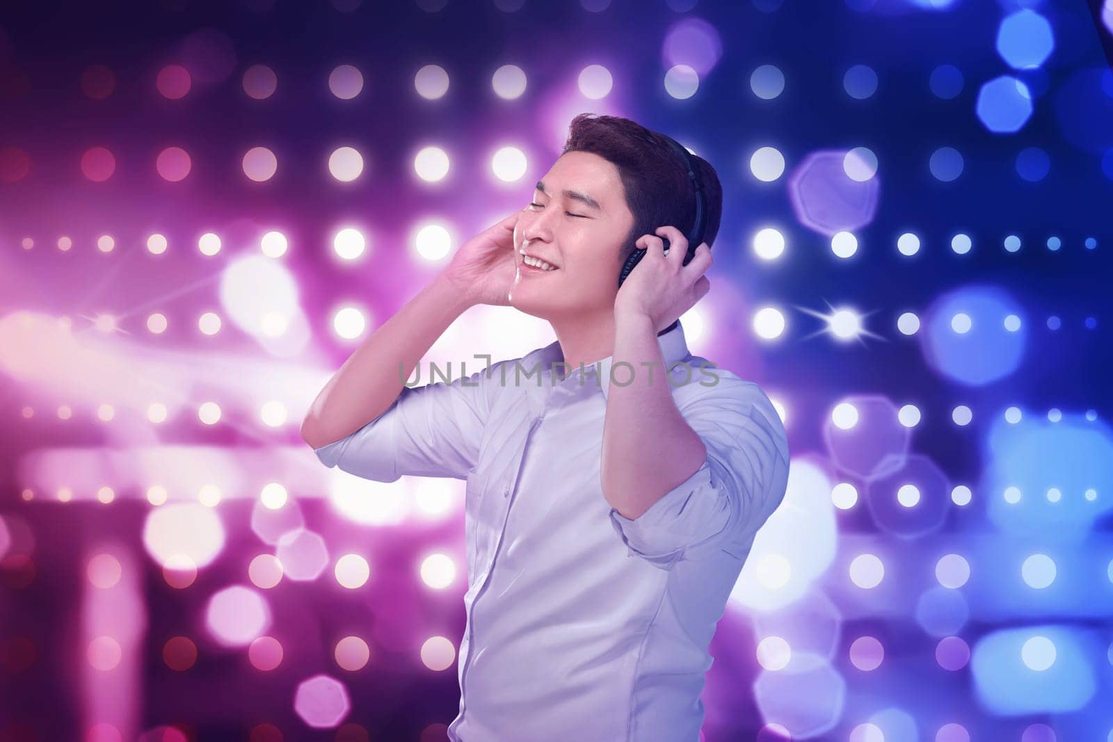 Young asian man listening music headphones with relax over blurred light background
