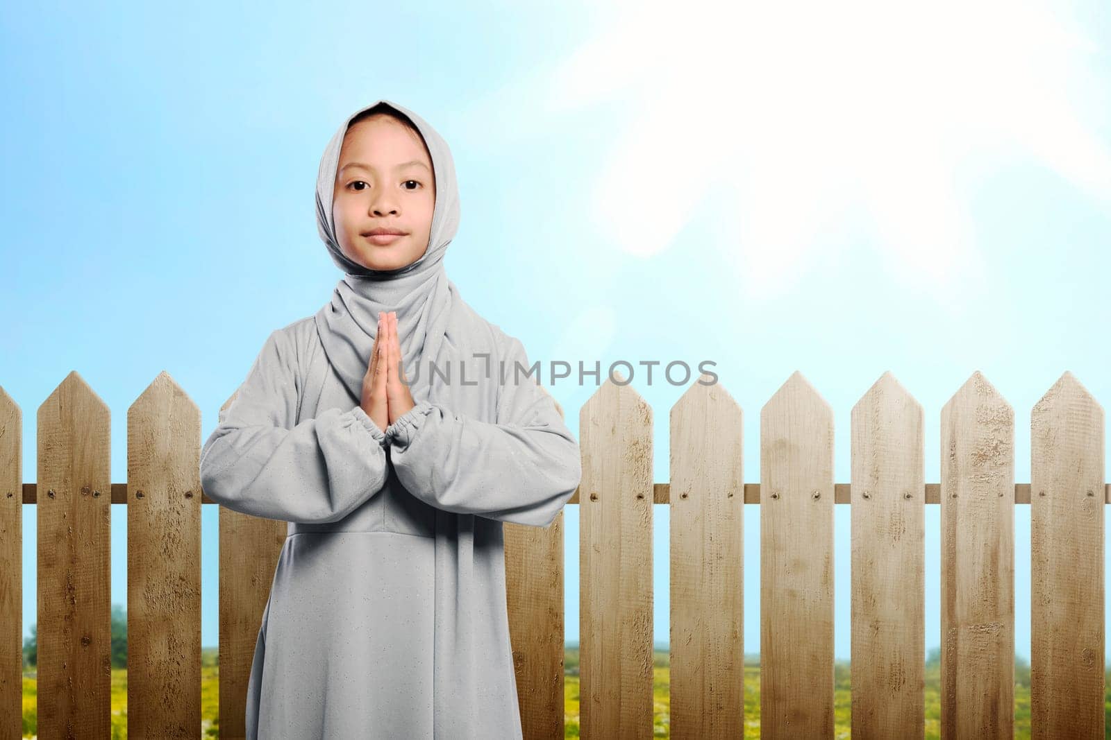 Little asian muslim child with hijab praying at outdoor