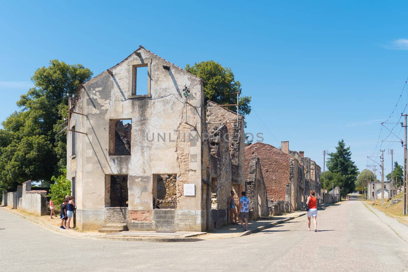 ORADOUR-SUR-GLANE, FRANCE - AUGUST 15, 2016: Tourists between the ruins of the by the nazis destroyed french village in WW2