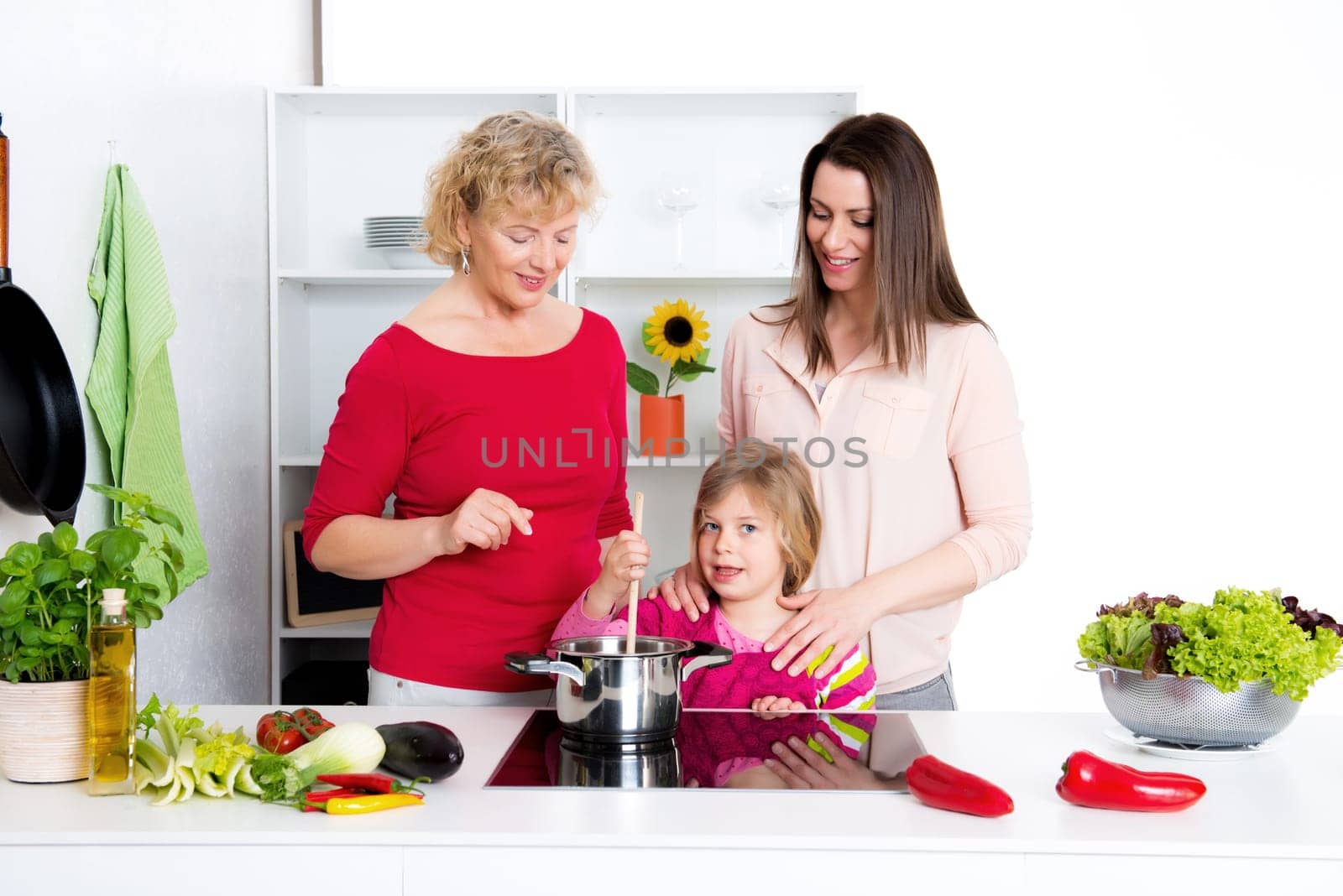 woman with daughter and grandchild together cooking together in the kitchen